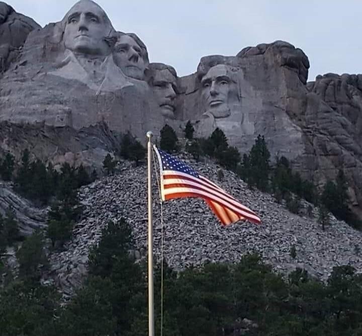 American flag in front of Mount Rushmore.