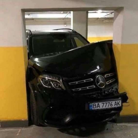 Черный внедорожник Mercedes-Benz застрял носом в стену в подземном паркинге. Передняя часть повреждена. Номерной знак: BA 7776 AK.