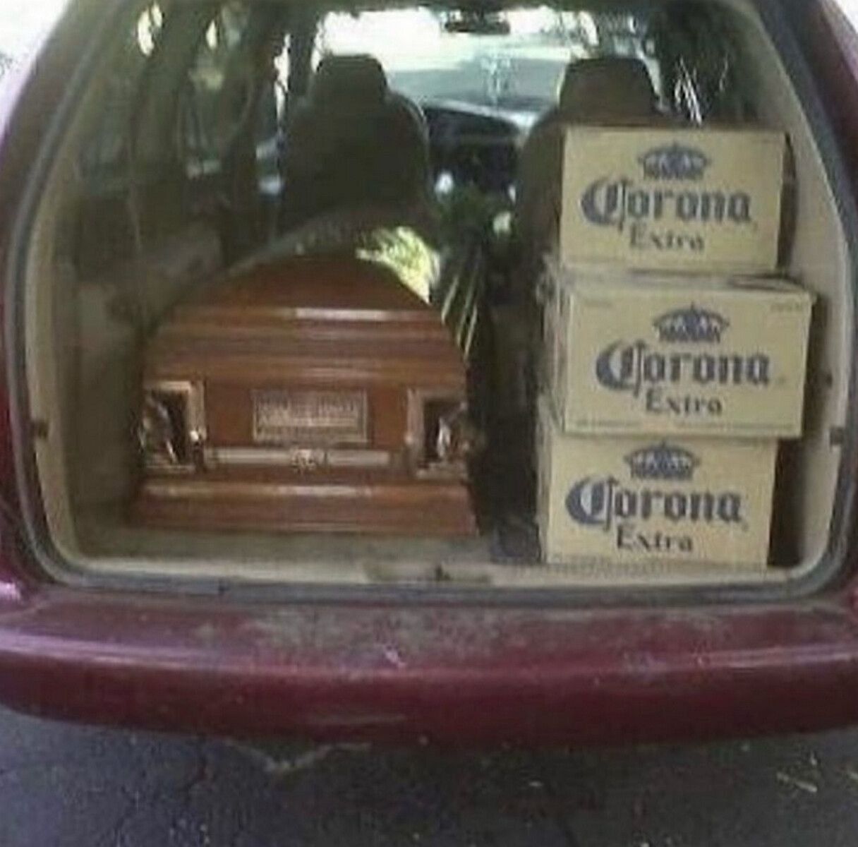 В багажнике автомобиля лежит гроб и коробки пива Corona Extra.