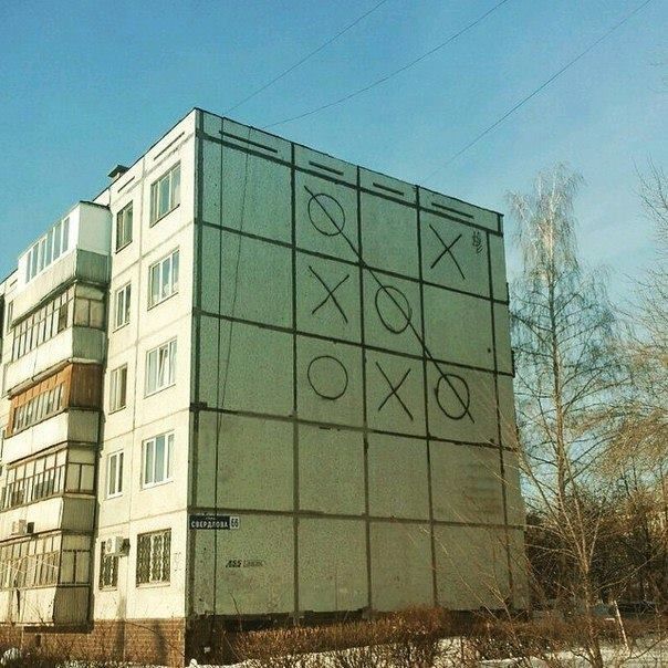 На стене жилого дома нарисована большая сетка крестики-нолики с крестиками и ноликами.