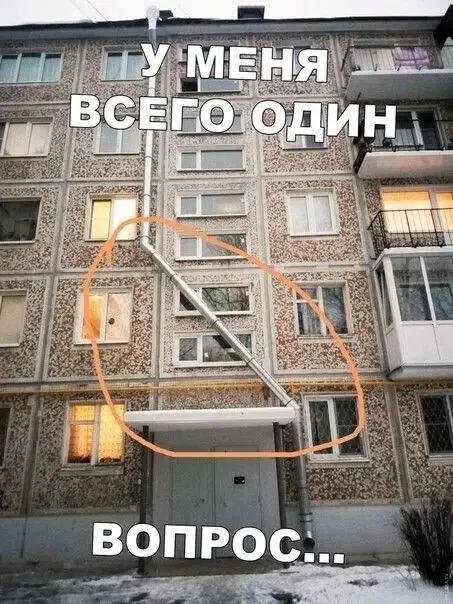 У МЕНЯ ВСЕГО ОДИН ВОПРОС... На изображении показан фасад жилого дома с необычно установленной водосточной трубой, которая идет вверх, затем по диагонали через несколько окон и снова вниз к подъезду. Оранжевый круг выделяет эту трубу.