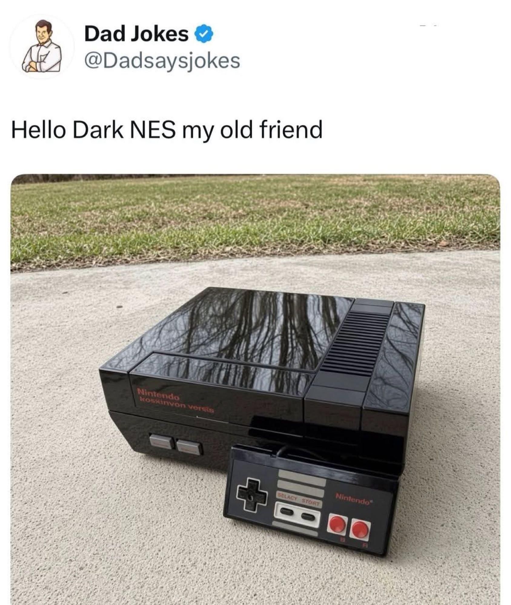 Dad Jokes @Dadsaysjokes Hello Dark NES my old friend. The image shows a black Nintendo console with a matching controller. Text on the console reads 'Nintendo kosxinon versis' and on the controller 'SELACY STORT Nintendo'.