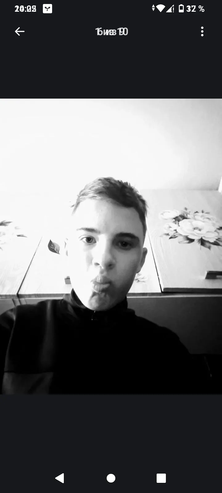 Чёрно-белое селфи молодого человека, он изображает поцелуй (наклонённый к камере, глаза смотрят вперёд).