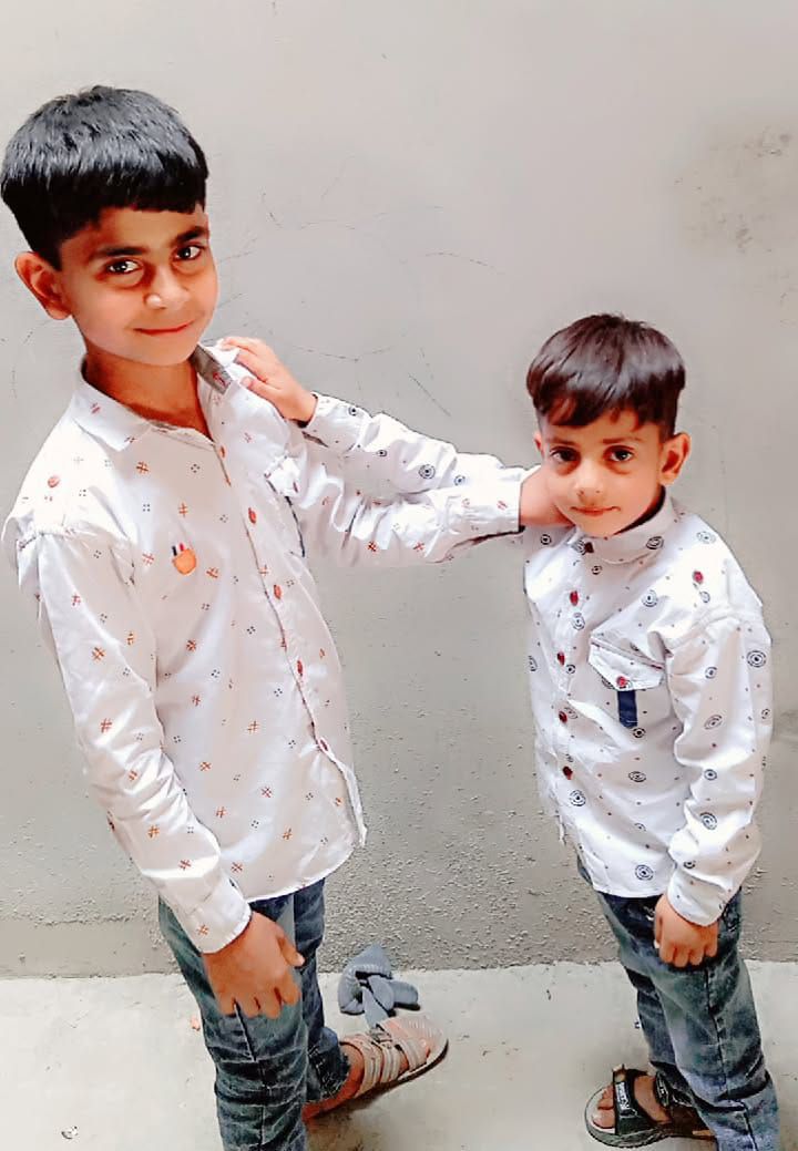Two young boys posing together.