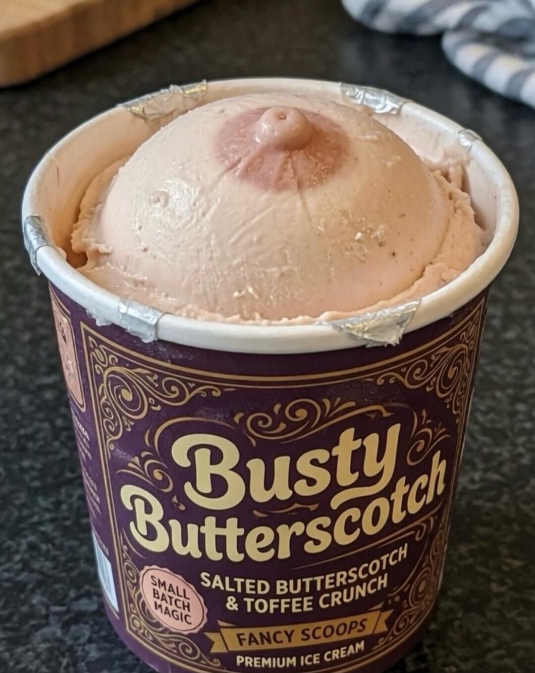 Busty Butterscotch Small Batch Magic Salted Butterscotch & Toffee Crunch Fancy Scoops Premium Ice Cream. The ice cream is humorously shaped like a breast with a nipple.