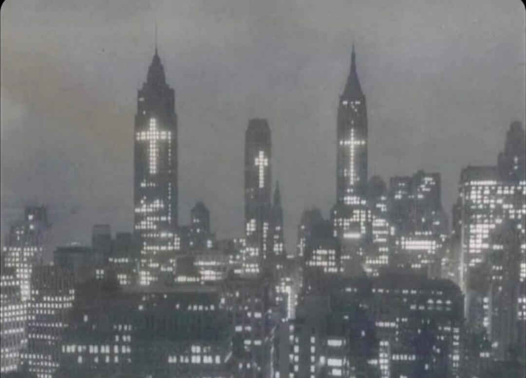 City skyline at night with illuminated crosses on tall buildings.