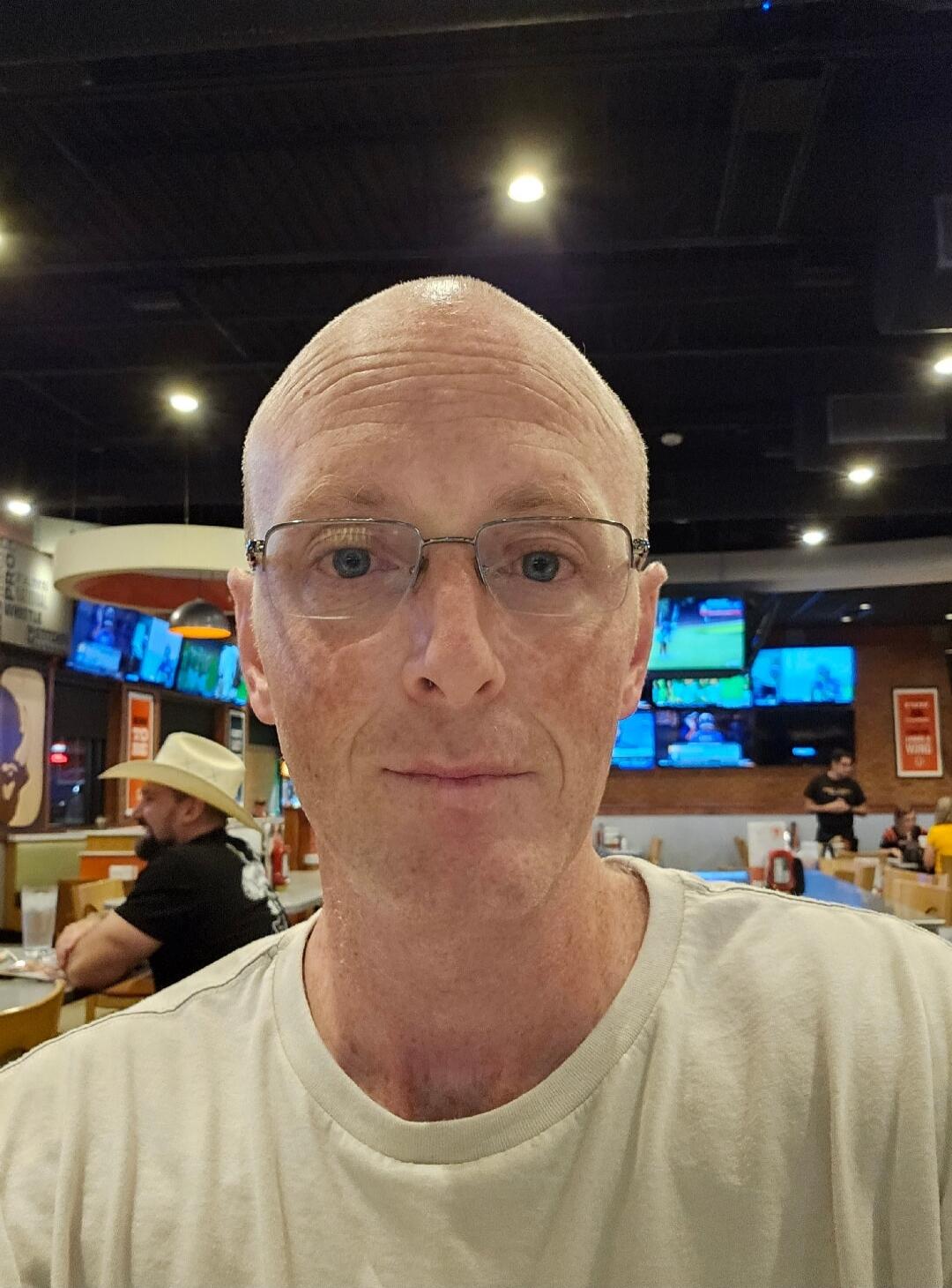 A man taking a selfie in a restaurant.