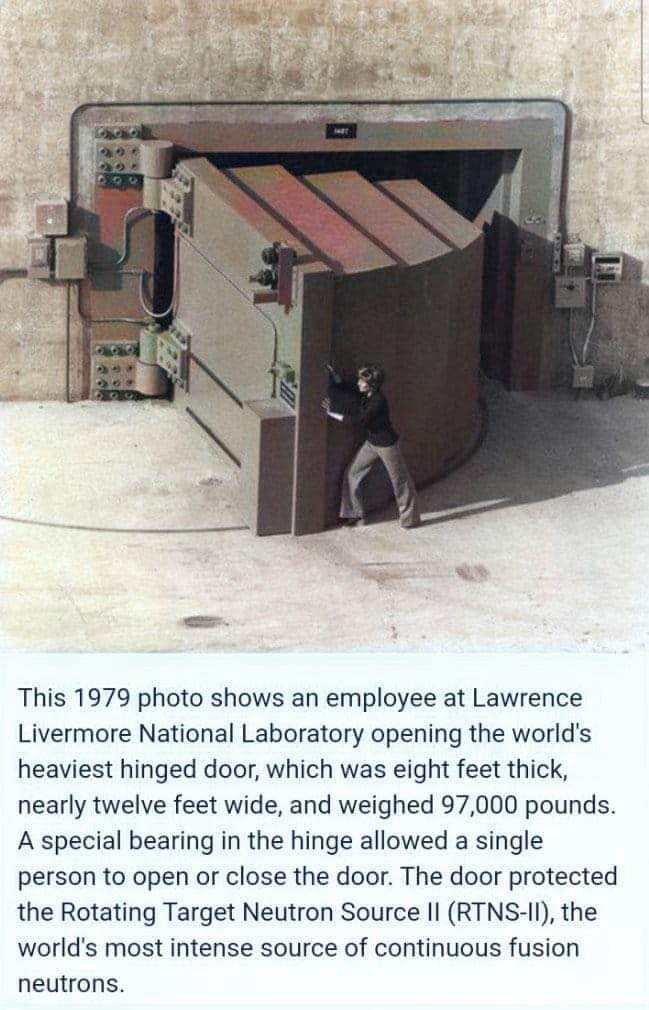 This 1979 photo shows an employee at Lawrence Livermore National Laboratory opening the worlds heaviest hinged door which was eight feet thick nearly twelve feet wide and weighed 97000 pounds A special bearing in the hinge allowed a single person to open or close the door The door protected the Rotating Target Neutron Source Il RTNS II the worlds most intense source of continuous fusion neutrons