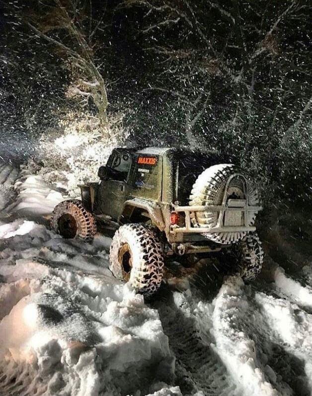 The off-road vehicle is driving through deep snow.