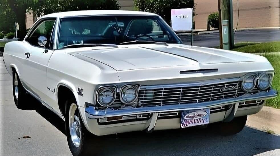 A classic white Chevrolet Impala car, possibly from the mid-1960s, parked outdoors.