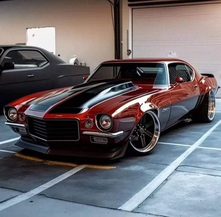 Red and blue striped classic muscle car with wide stance and custom rims parked in a lot.