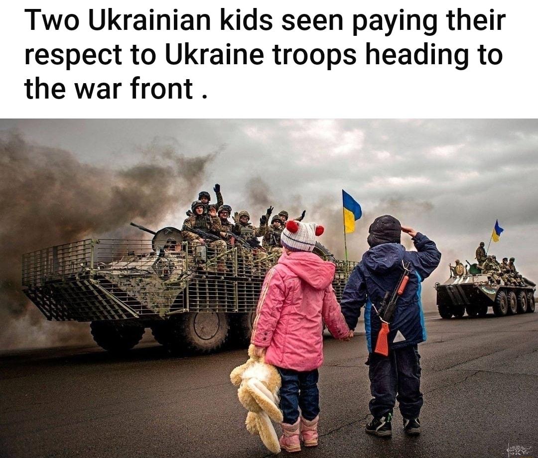 Two Ukrainian kids seen paying their respect to Ukraine troops heading to the war front