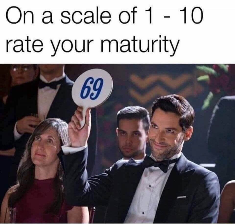 On a scale of 1 - 10 rate your maturity. A man holding an auction paddle with the number 69, smirking mischievously.