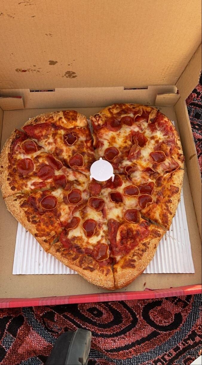 Heart-shaped pepperoni pizza in a pizza box.