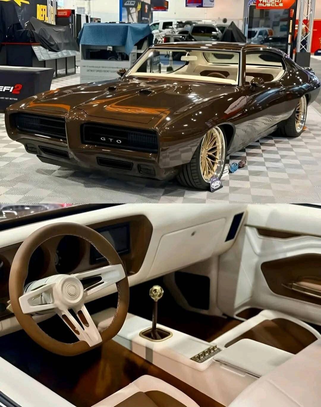 Pontiac GTO on display with a brown exterior. Interior features a white/tan color scheme, a custom steering wheel, and a manual gear shifter.