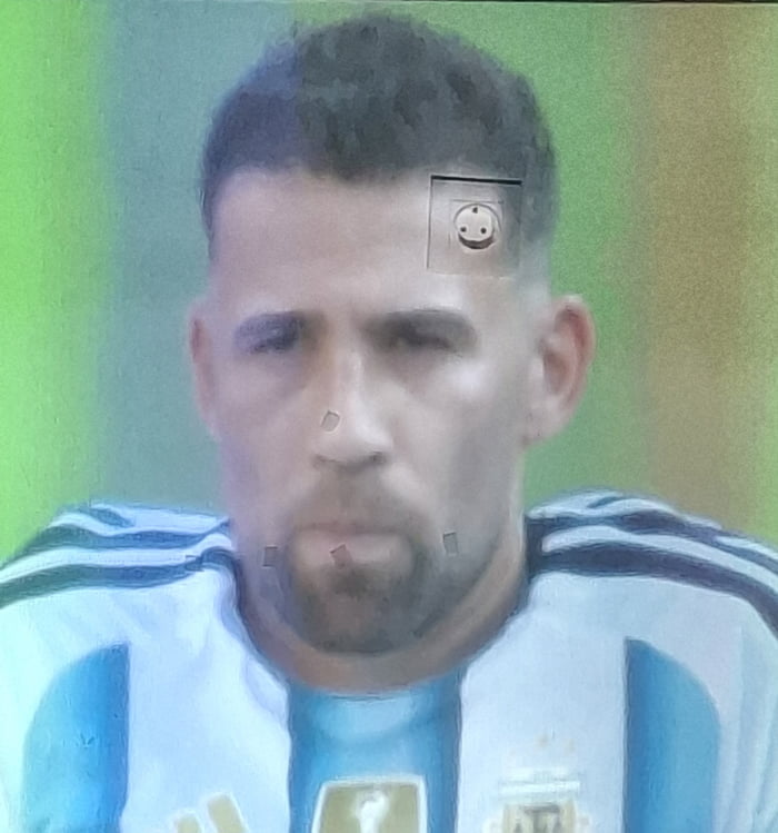 A man in an Argentina football jersey with a power outlet symbol edited onto his forehead.
