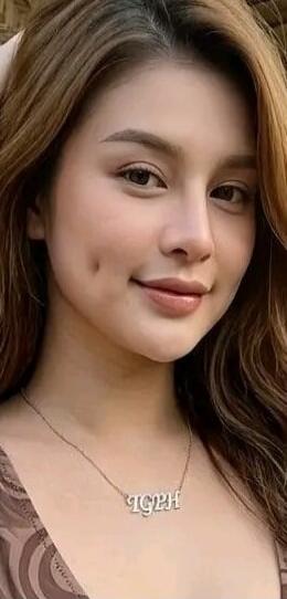 A young woman with a necklace that spells 'IGPH'.