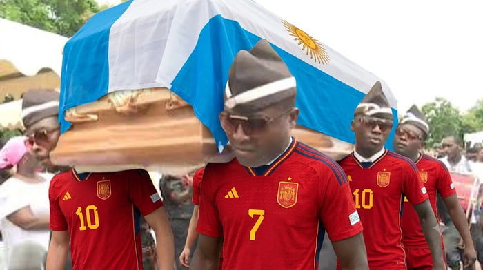 Ghanaian pallbearers wearing Spain national football team jerseys carry a coffin draped with the flag of Argentina.