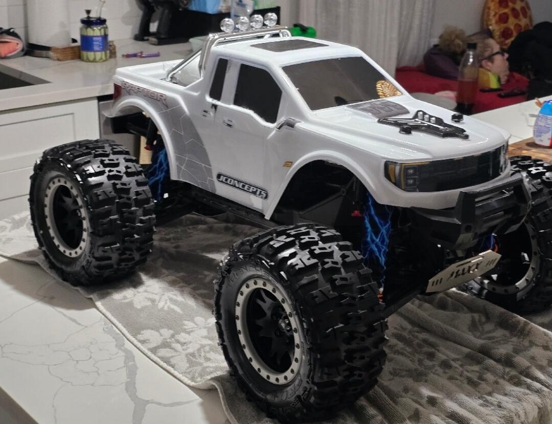 White RC monster truck with large tires on a kitchen table.