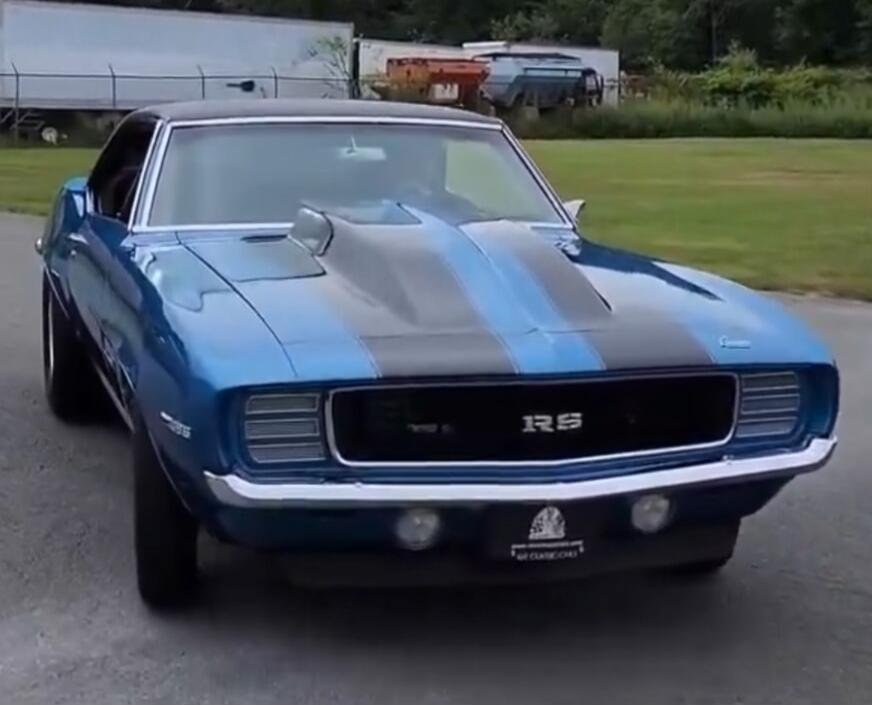 Blue vintage car with racing stripes and an RS badge on the grille.