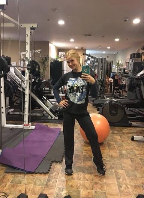 A woman is wearing a black long-sleeved shirt with the word 'EVOLVE' printed on it.