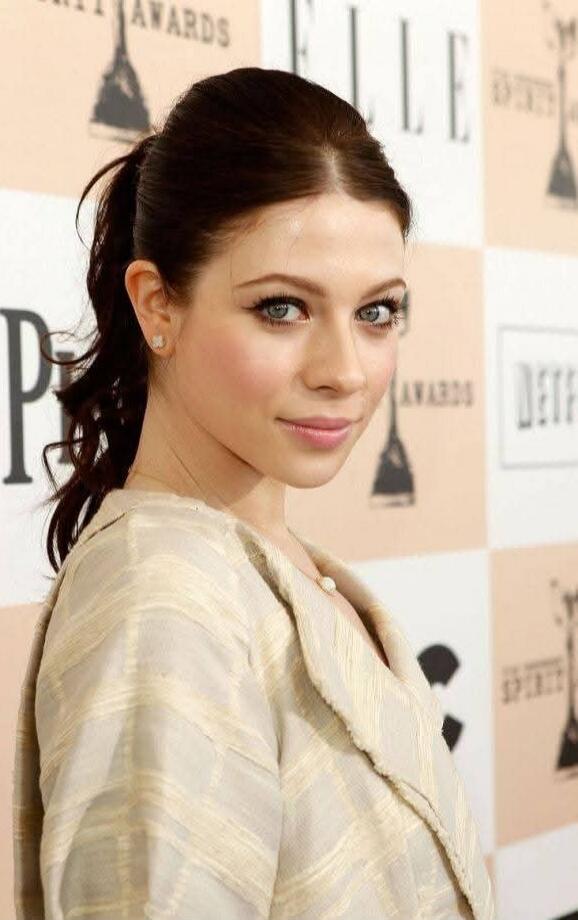 Elle Awards (red carpet backdrop) – a woman posing in a light striped coat/dress.