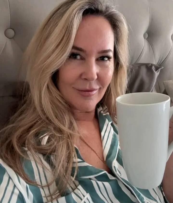 A woman holding a white mug.