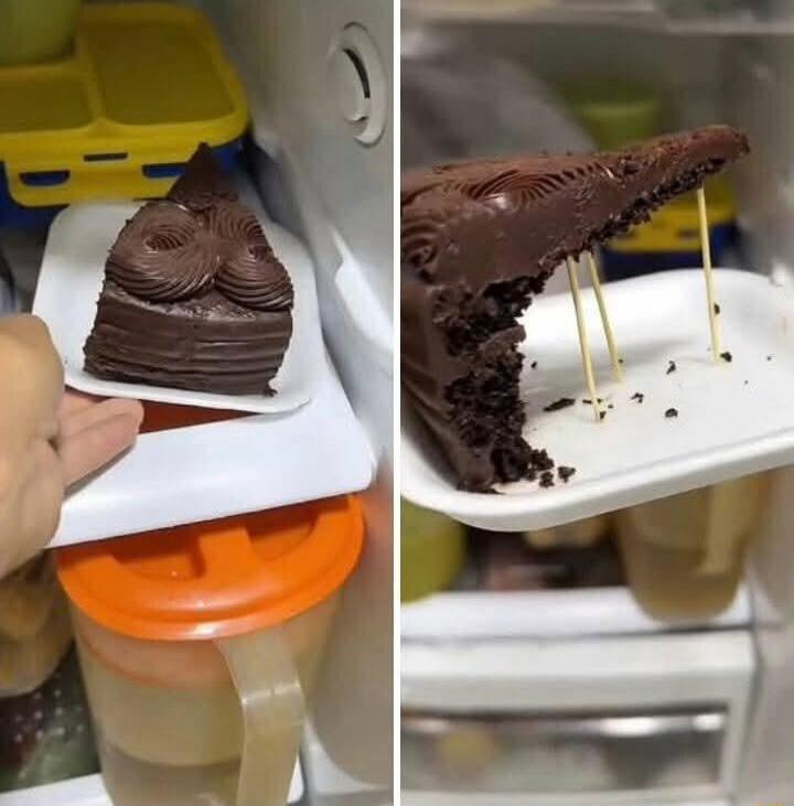 A chocolate cake slice on a plate being cut, with a bitten piece and toothpicks on the right.