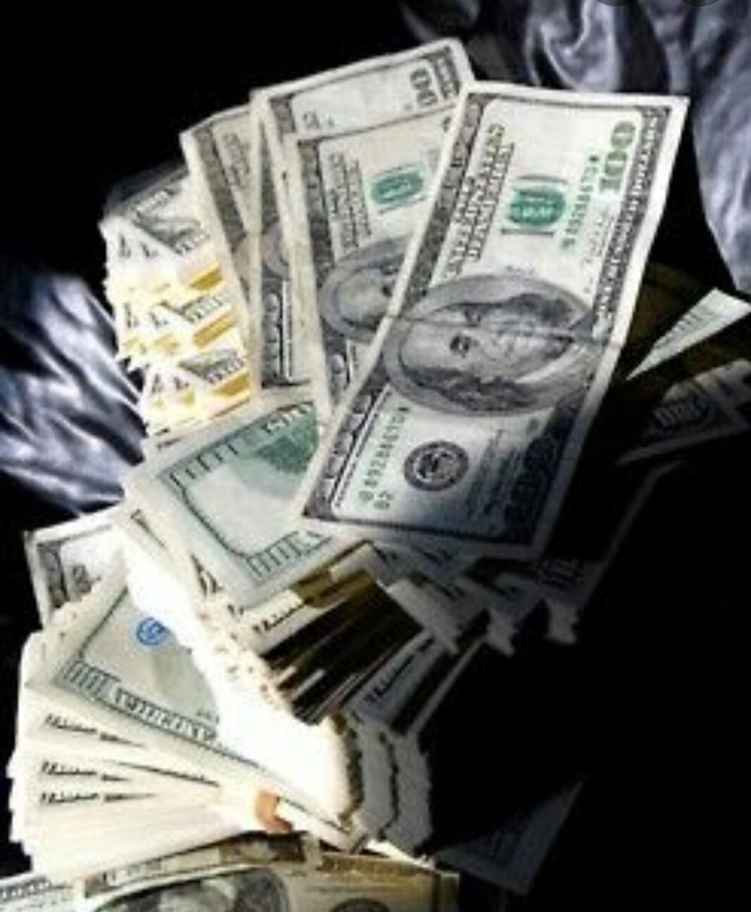 Stacks of US dollar bills, mostly one hundred dollar denominations.