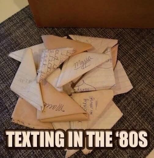 TEXTING IN THE '80S. A pile of folded paper notes, some with handwritten names like Maria, Tony, and Amy, and other illegible text.