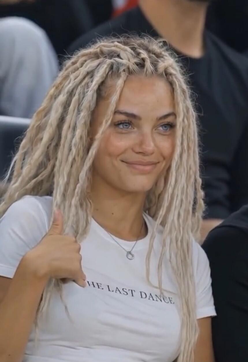 THE LAST DANCE. A young woman with blonde dreadlocks smiles and gives a thumbs up.