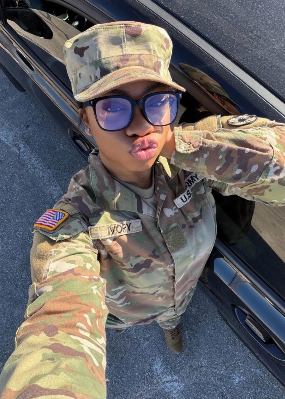 IVORY ARMY U.S. USA flag. A person in a military uniform is making a kiss face for a selfie.