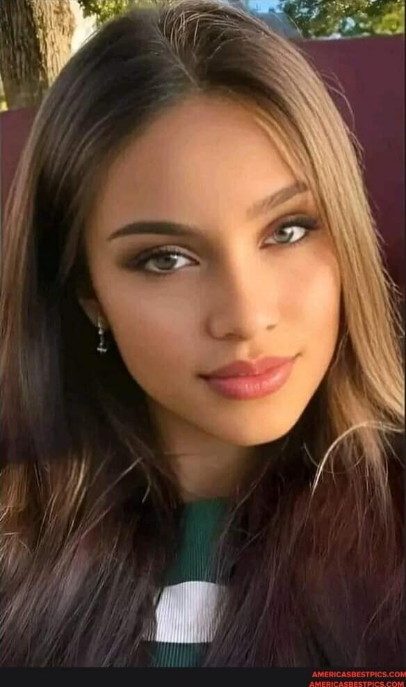 A portrait of a young woman with long hair and subtle makeup.