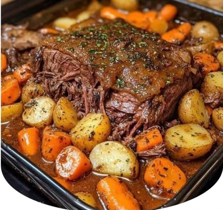A roasted beef cut with potatoes and carrots cooked in a rich brown gravy.