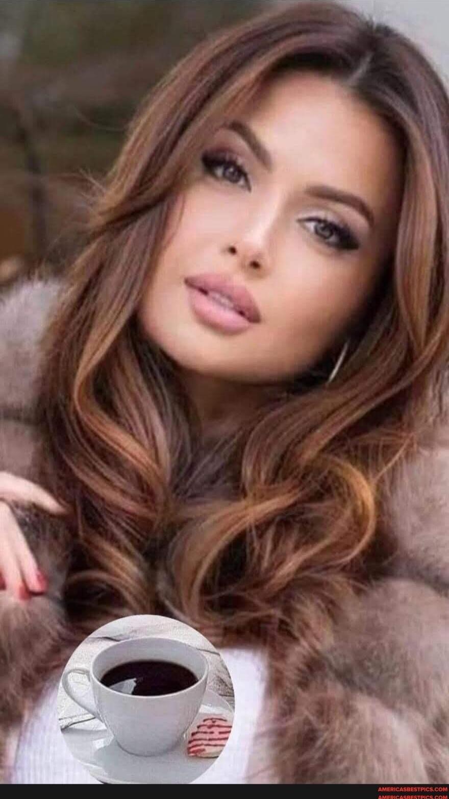 Portrait of a woman with long brown hair wearing a fur coat, with a cup of coffee.