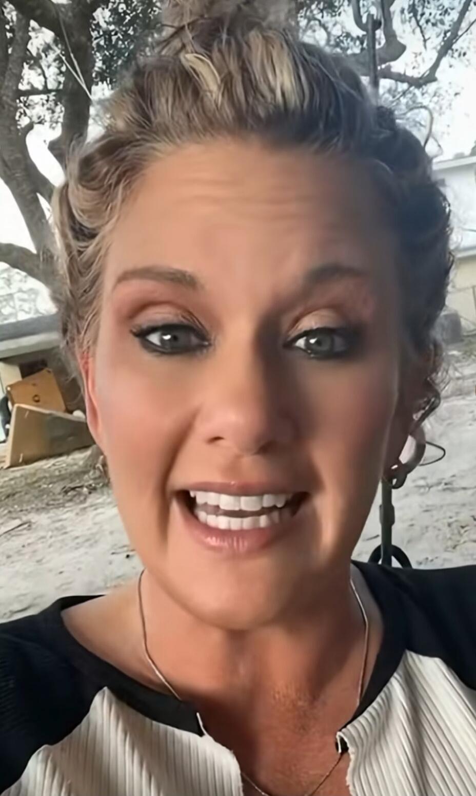 A woman with an animated expression is speaking directly to the camera, possibly explaining or reacting to something.