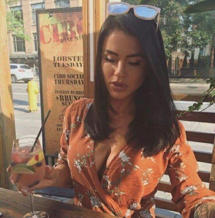 CIBO WINE BAR LOBSTER TUESDAY CIBO SOCIAL THURSDAY ITALIAN BUBBLE + BRUNCH SUN. A woman is sitting outdoors, holding a cocktail.