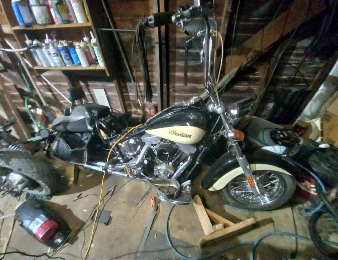 Vintage motorcycle in a cluttered garage/workshop.