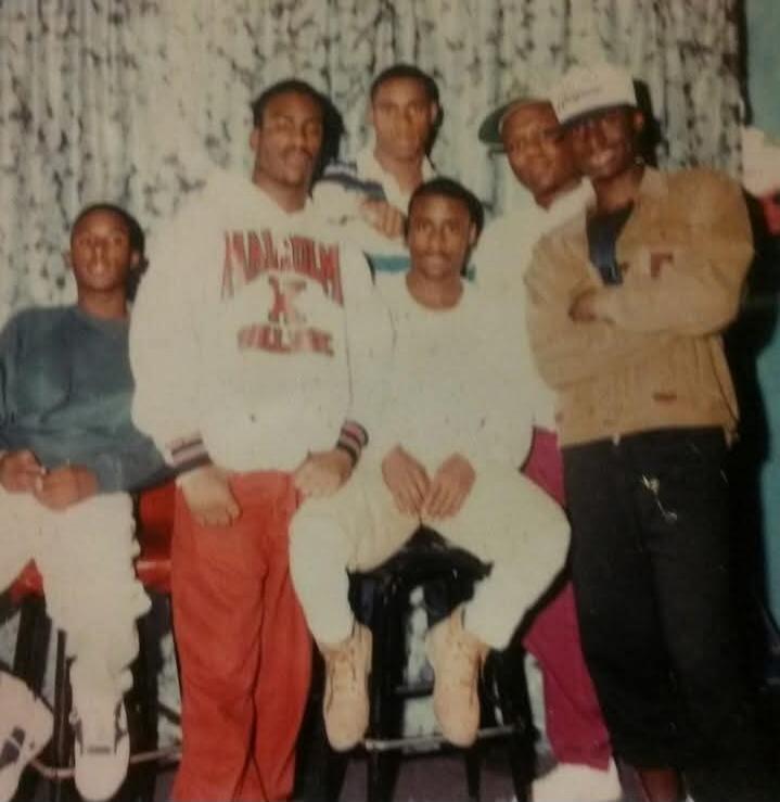 A group of young Black men posing together, likely friends, in what appears to be an older photograph.