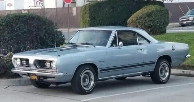 Light blue vintage car parked in a lot.