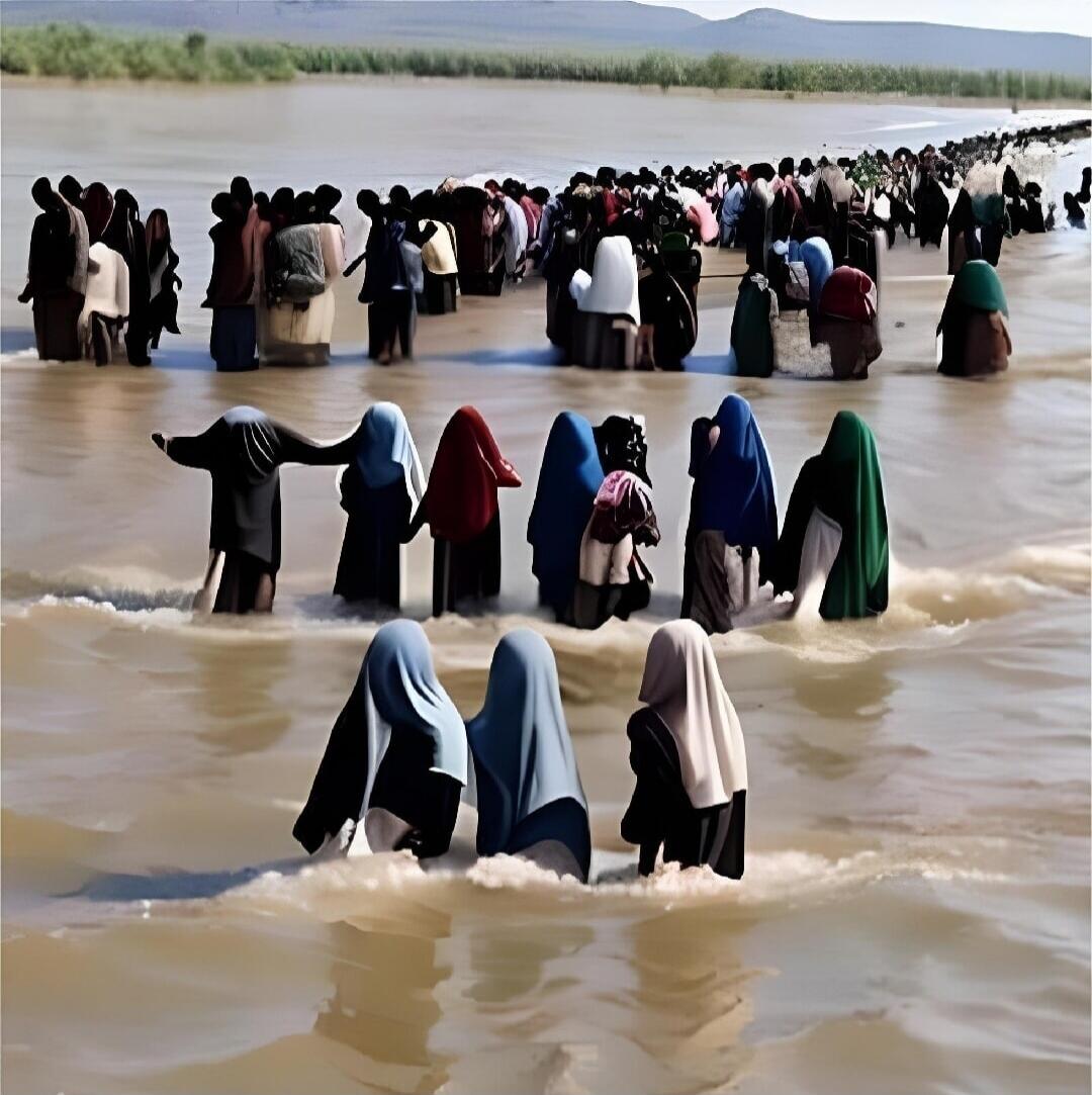 A group of people are wading through a body of water, possibly a river or floodwaters. They are dressed in various clothing, some with head coverings. The scene appears to depict a migration or a rescue effort.