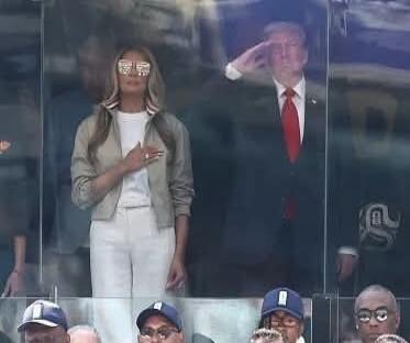 Beyoncé and Donald Trump are seen in a public setting, possibly a stadium. Trump is saluting, while Beyoncé has her hand over her heart.