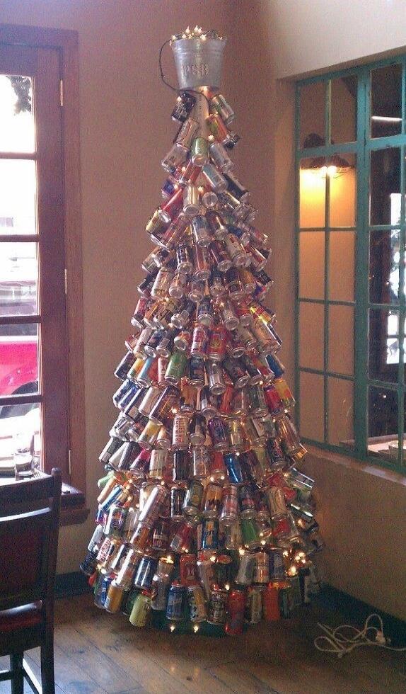 A Christmas tree made of stacked aluminum cans with a metal bucket on top.