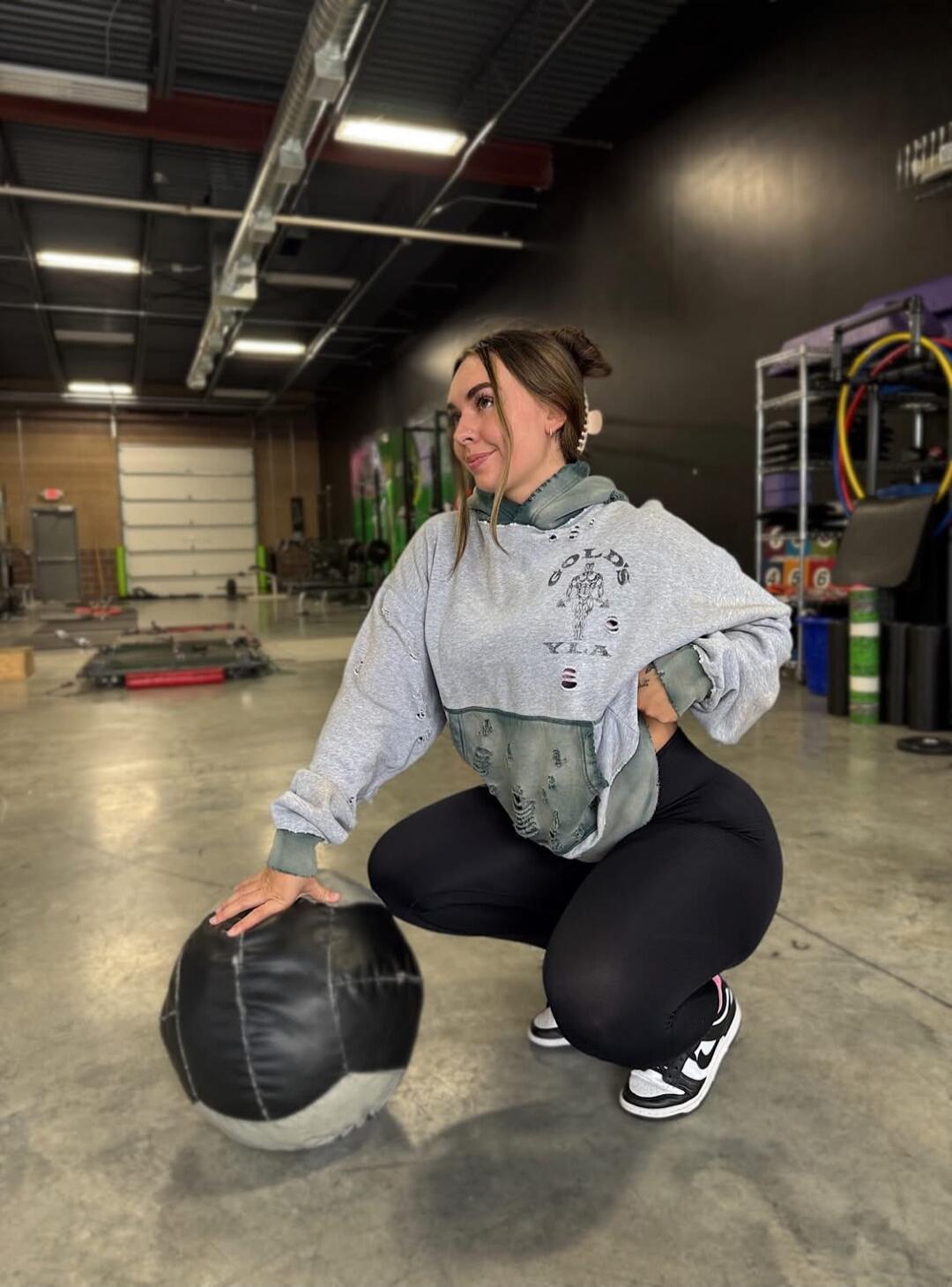 woman squatting with a medicine ball in a gym