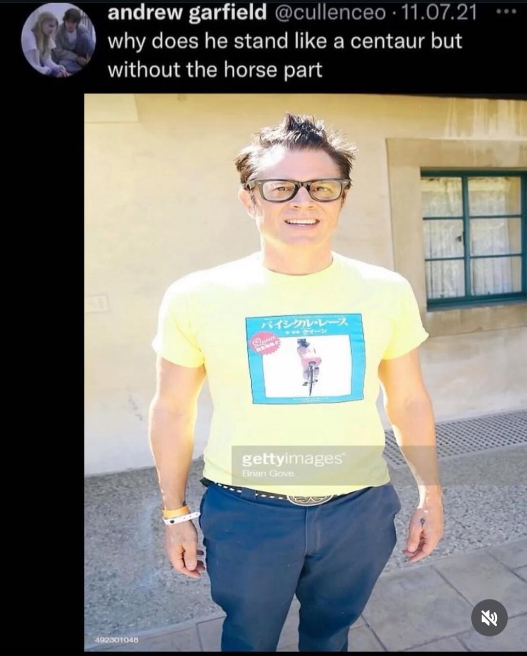 andrew garfield @cullenceo · 11.07.21 why does he stand like a centaur but without the horse part. A man, Johnny Knoxville, is smiling and wearing a yellow t-shirt with Japanese text that reads 'Bicycle Race' and 'Queen' and an image of a woman on a bicycle. Below the image, 'gettyimages Brian Gove' and '492301048' are visible.