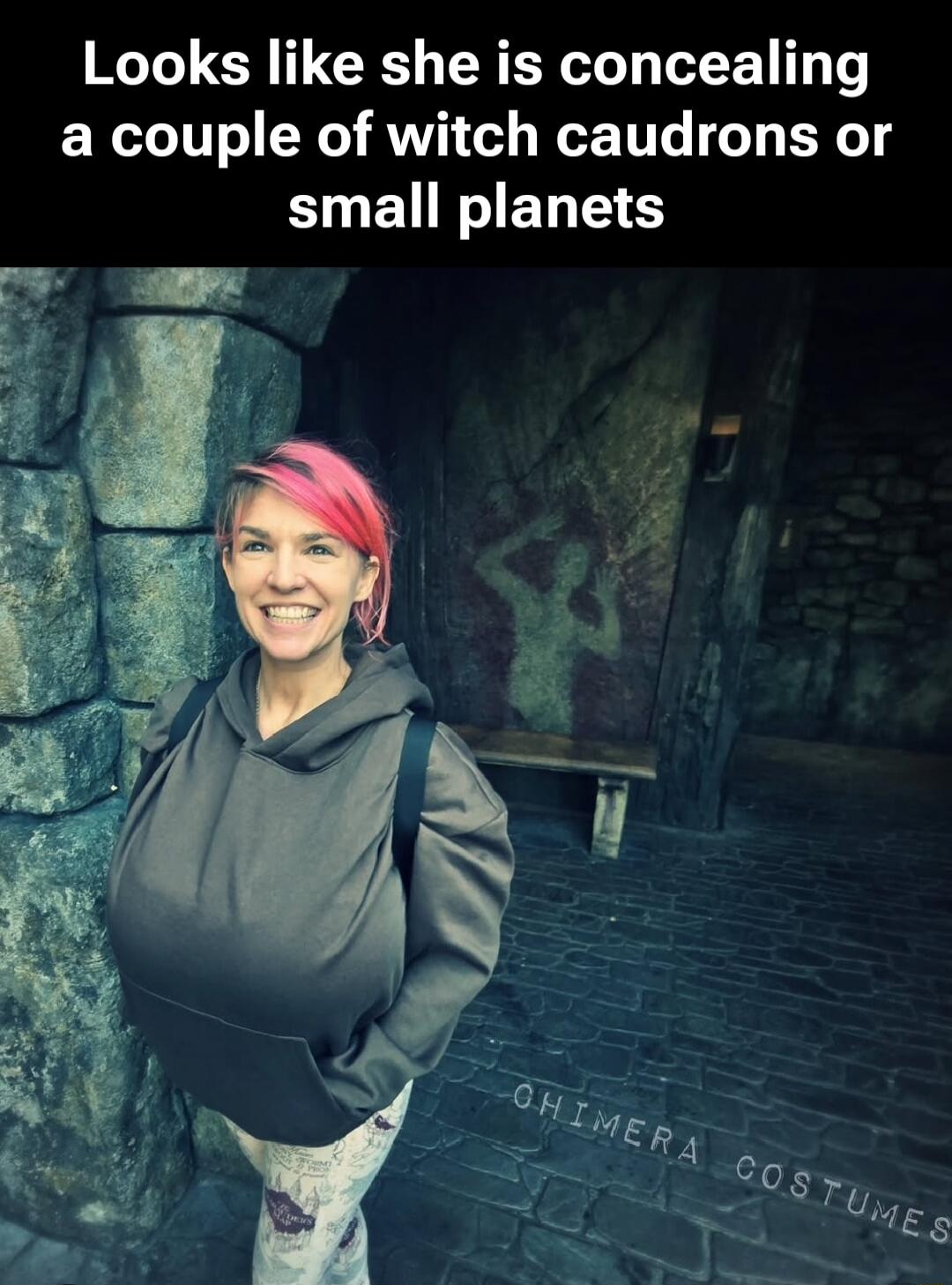 Looks like she is concealing a couple of witch cauldrons or small planets