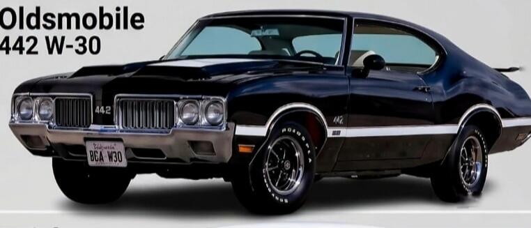 Oldsmobile 442 W-30. A classic black muscle car with a California license plate BGA W30. The car features '442' badging on the grille and 'GOOD YEAR' tires.