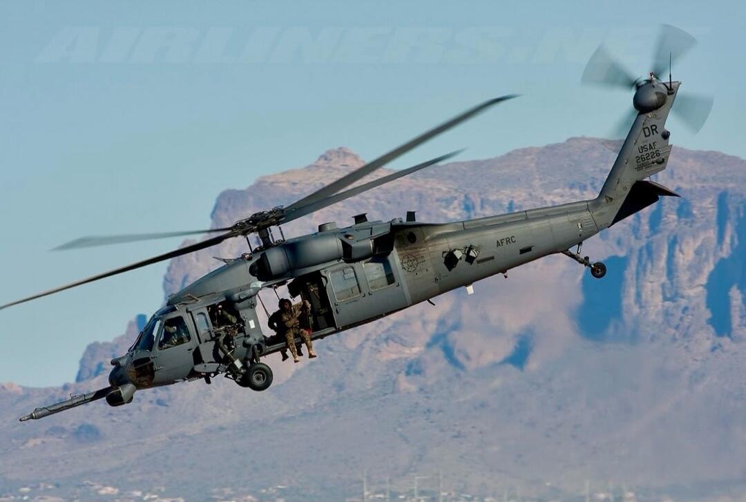 Military helicopter in flight with soldiers on board.