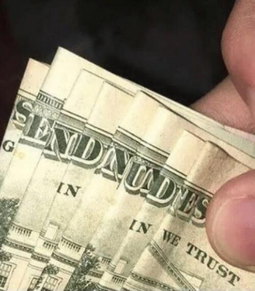 The image displays several US dollar bills folded to spell out the phrase 'SEND NUDES'. Parts of the original text 'IN GOD WE TRUST' are also partially visible on the bills.