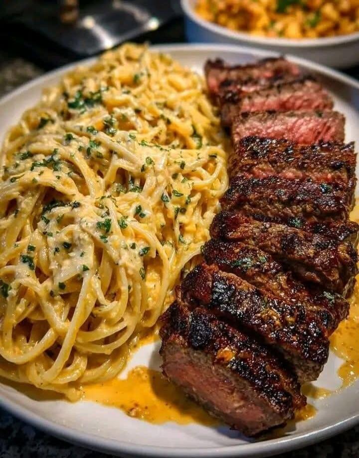 Plate with creamy pasta and sliced steak.